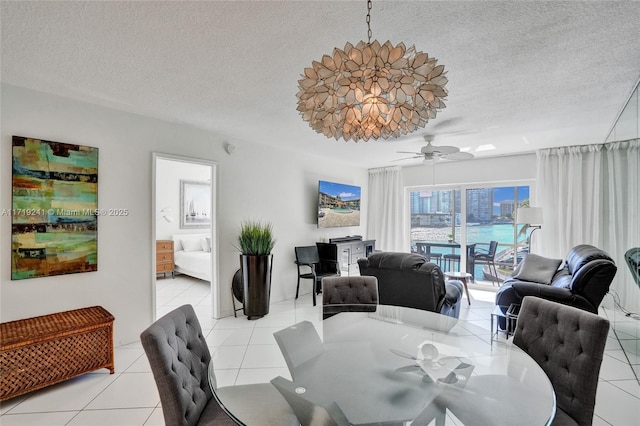 dining space featuring a ceiling fan, a textured ceiling, and light tile patterned flooring