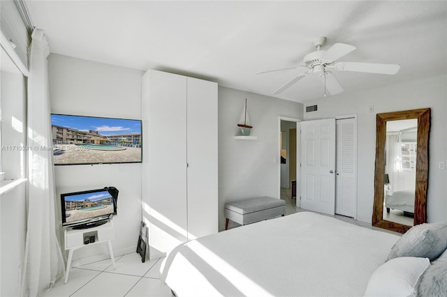bedroom featuring baseboards, ceiling fan, light tile patterned flooring, and visible vents