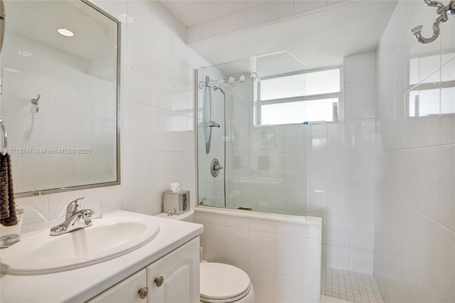 bathroom featuring vanity, tile walls, toilet, and tiled shower