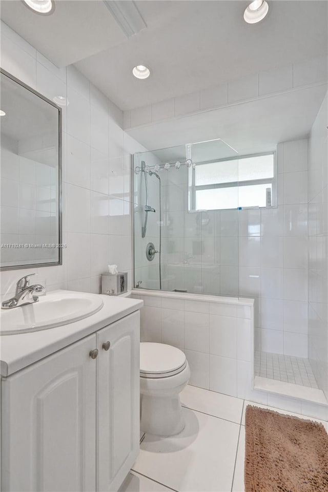 bathroom featuring vanity, tile patterned flooring, toilet, tile walls, and tiled shower / bath combo