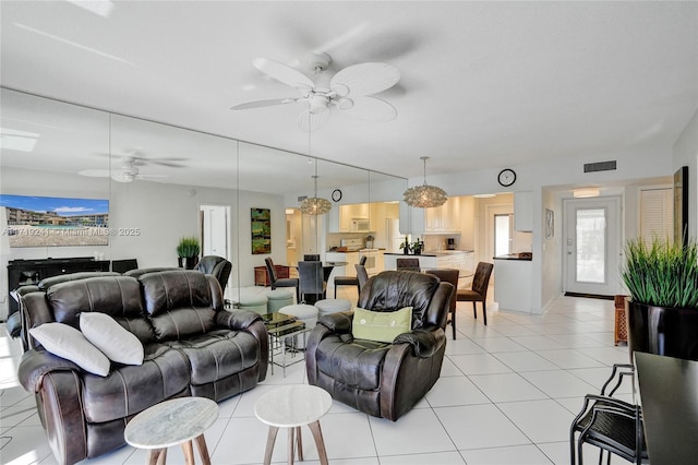 living room with visible vents, a ceiling fan, and light tile patterned floors