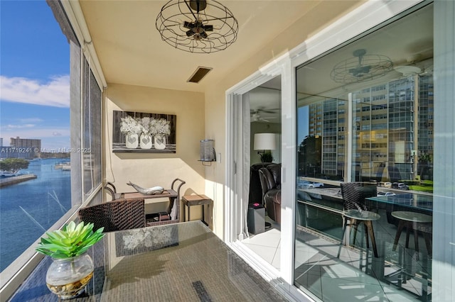 exterior space with a water view, a ceiling fan, and visible vents