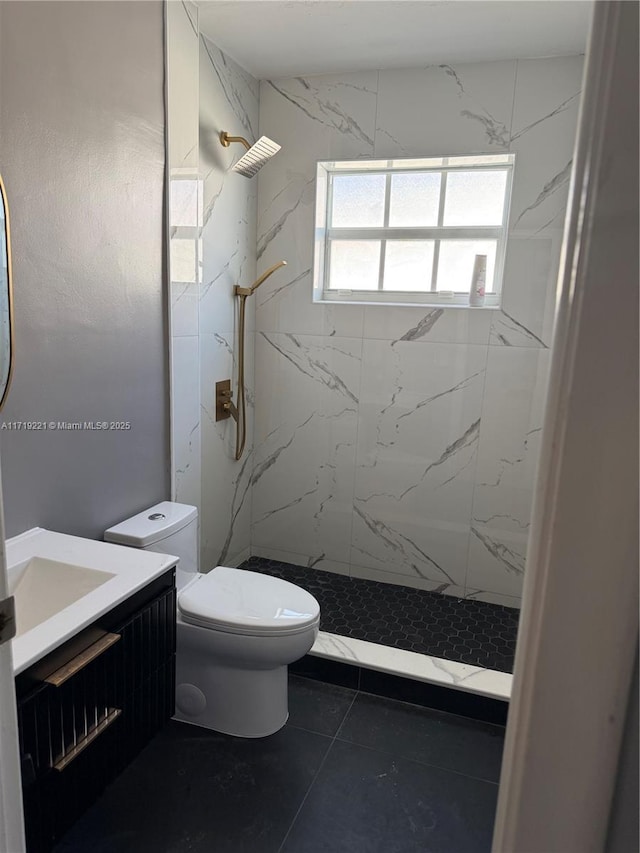 bathroom with tile patterned flooring, a tile shower, vanity, and toilet