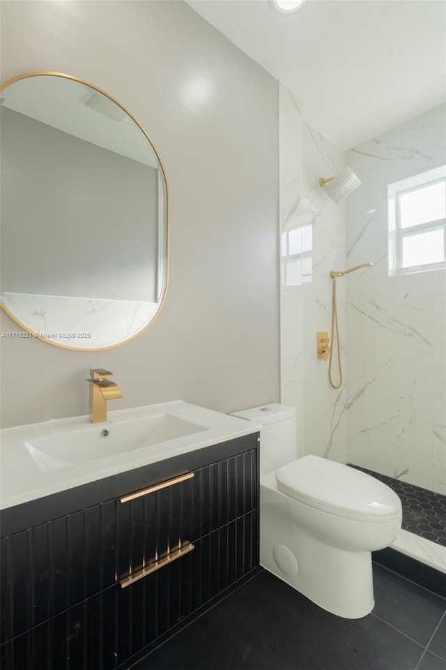 full bath featuring toilet, a marble finish shower, and vanity