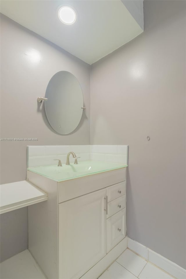 bathroom featuring tile patterned flooring, vanity, and baseboards