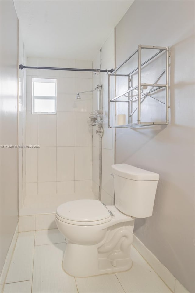 full bath with baseboards, a stall shower, toilet, and tile patterned floors