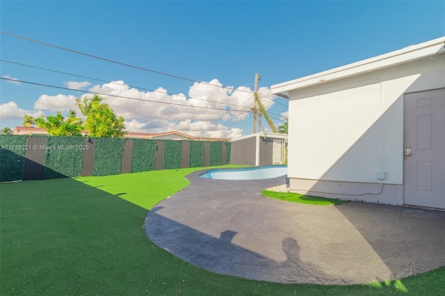 view of yard featuring a fenced in pool, a fenced backyard, a patio, and an outdoor structure