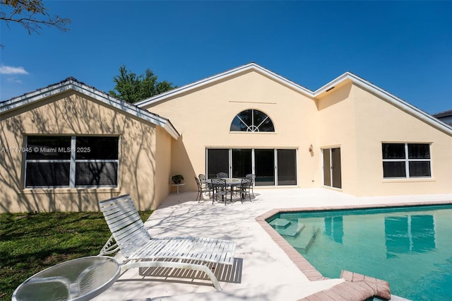 13080 NW 8th Ct, Sunrise, FL 33325 - rear view of property featuring a patio area, stucco siding, and an outdoor pool