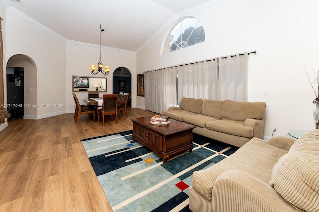 13080 NW 8th Ct, Sunrise, FL 33325 - living room with arched walkways, a chandelier, wood finished floors, high vaulted ceiling, and crown molding