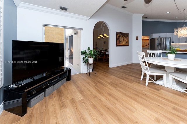 13080 NW 8th Ct, Sunrise, FL 33325 - living area with a chandelier, ornamental molding, light wood-type flooring, a ceiling fan, and arched walkways