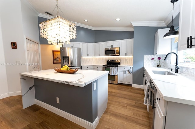 13080 NW 8th Ct, Sunrise, FL 33325 - kitchen with appliances with stainless steel finishes, crown molding, a center island, a chandelier, and light wood-type flooring