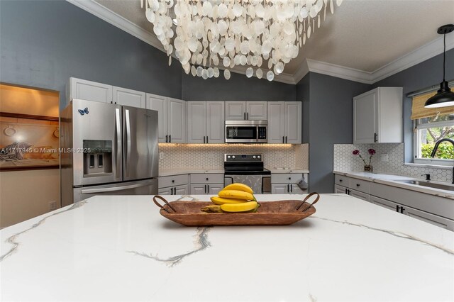 13080 NW 8th Ct, Sunrise, FL 33325 - kitchen with stainless steel appliances, backsplash, light stone counters, pendant lighting, and ornamental molding