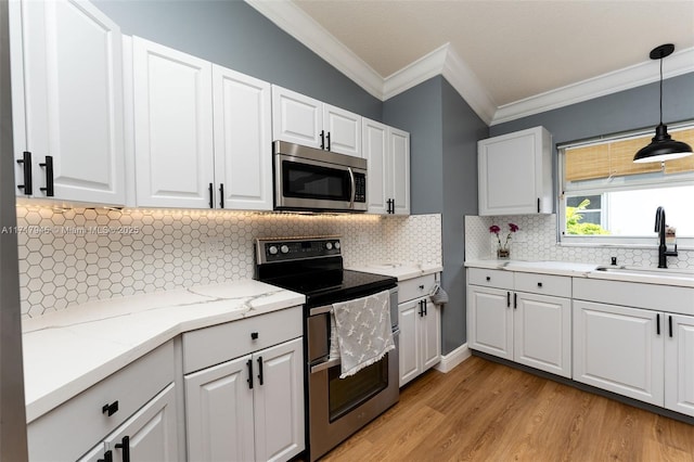 13080 NW 8th Ct, Sunrise, FL 33325 - kitchen with stainless steel appliances, ornamental molding, light wood-style flooring, decorative light fixtures, and white cabinets