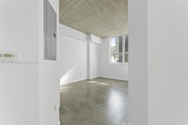 empty room featuring concrete flooring and electric panel