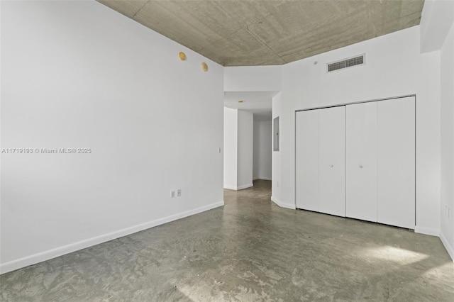 unfurnished bedroom featuring concrete floors and a closet