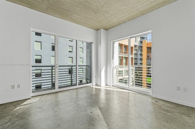 unfurnished room with concrete flooring