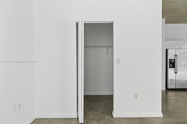 unfurnished bedroom with stainless steel fridge and a closet