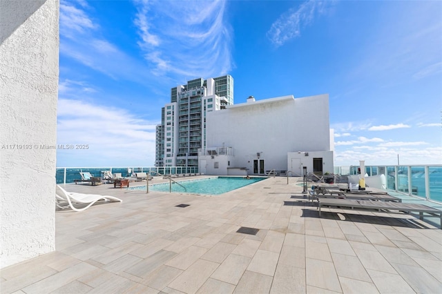 view of swimming pool featuring a water view and a patio area