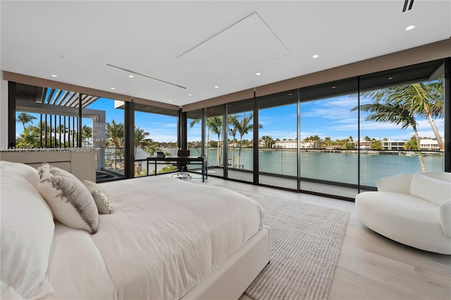 315 N Shore Dr, Miami Beach, FL 33141 - bedroom featuring access to outside, a wall of windows, a water view, wood finished floors, and multiple windows