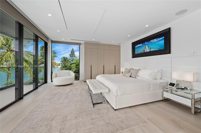 315 N Shore Dr, Miami Beach, FL 33141 - bedroom featuring a water view, light wood-type flooring, recessed lighting, and floor to ceiling windows