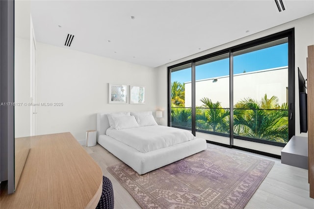 315 N Shore Dr, Miami Beach, FL 33141 - bedroom with access to outside, visible vents, and light wood-type flooring