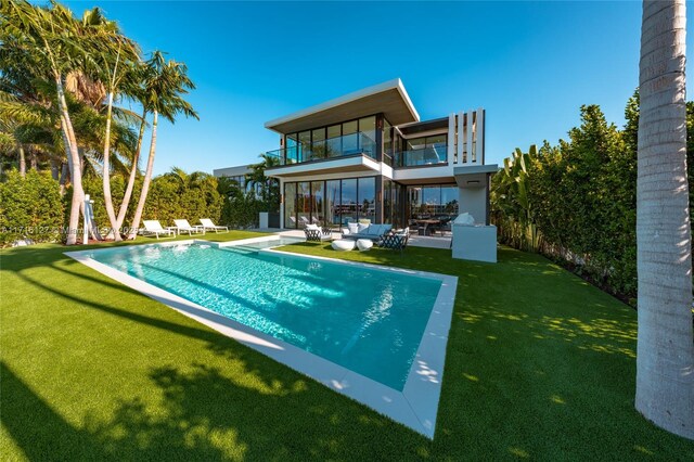 315 N Shore Dr, Miami Beach, FL 33141 - back of property with a patio area, a fenced in pool, a lawn, and a balcony
