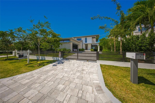 315 N Shore Dr, Miami Beach, FL 33141 - exterior space featuring a fenced front yard, a front yard, stucco siding, and a gate