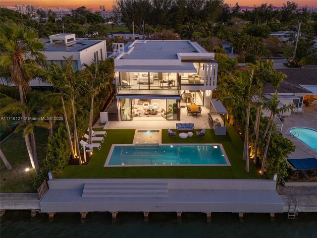 315 N Shore Dr, Miami Beach, FL 33141 - back of house featuring a patio area, a balcony, and a lawn