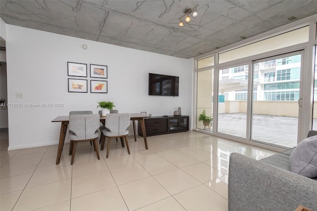 dining room featuring light tile patterned floors and a wall of windows