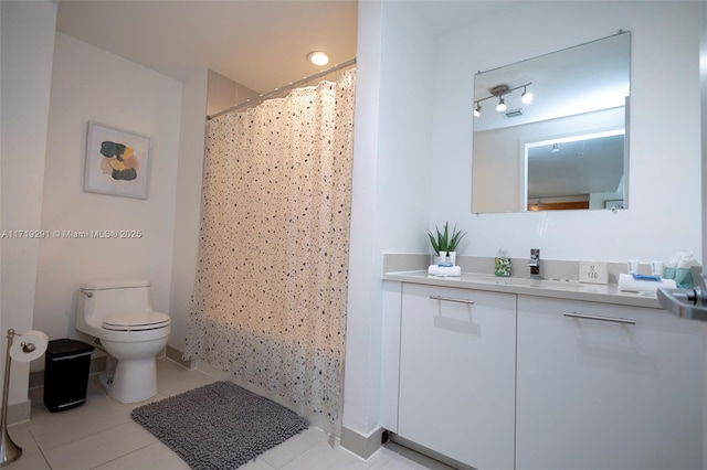 bathroom with tile patterned floors, vanity, curtained shower, and toilet