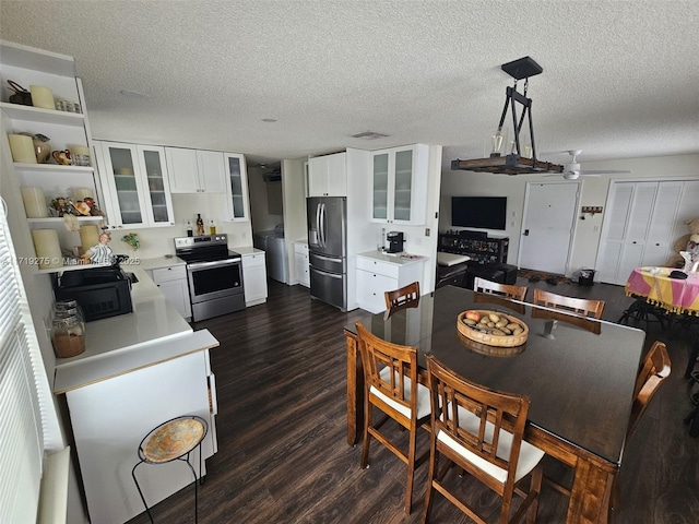 dining space with ceiling fan, dark wood-type flooring, a textured ceiling, and washer / dryer