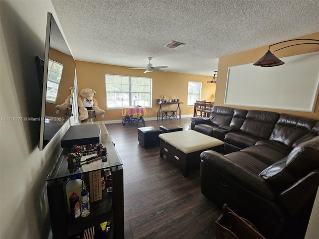 living room with ceiling fan, dark hardwood / wood-style flooring, and a textured ceiling