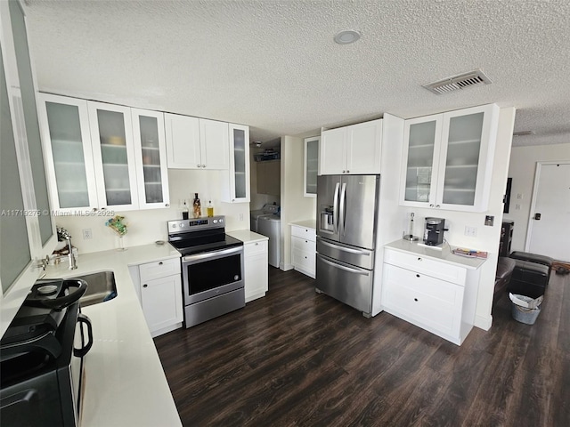 kitchen featuring appliances with stainless steel finishes, dark hardwood / wood-style flooring, a textured ceiling, sink, and white cabinets