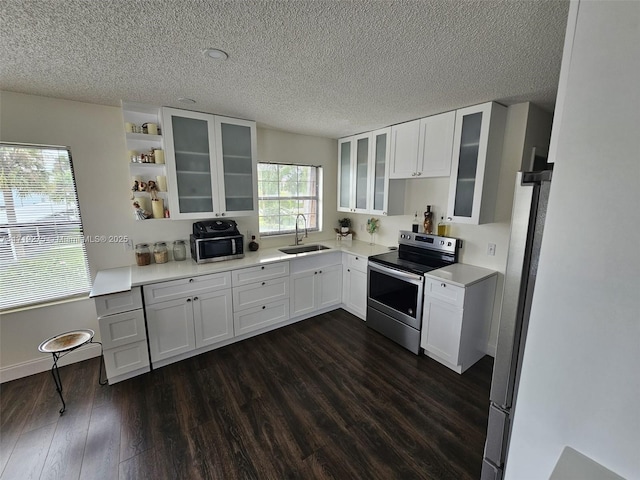 kitchen with white cabinets, electric stove, and sink