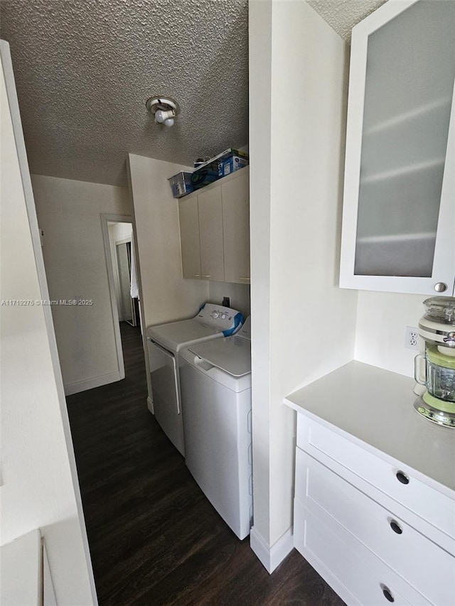 laundry area with a textured ceiling, dark hardwood / wood-style flooring, and washer and clothes dryer