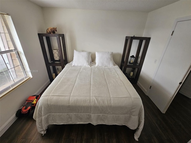 bedroom with dark hardwood / wood-style flooring