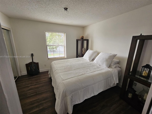 bedroom featuring a textured ceiling and dark wood-type flooring