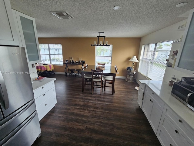 dining space featuring a textured ceiling and dark wood-type flooring