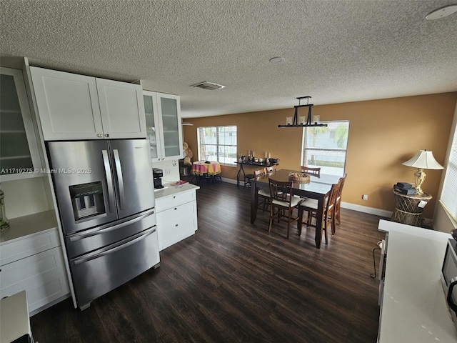 kitchen featuring white cabinetry, dark wood-type flooring, hanging light fixtures, and stainless steel refrigerator with ice dispenser