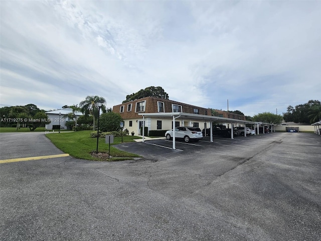 view of parking / parking lot featuring a yard