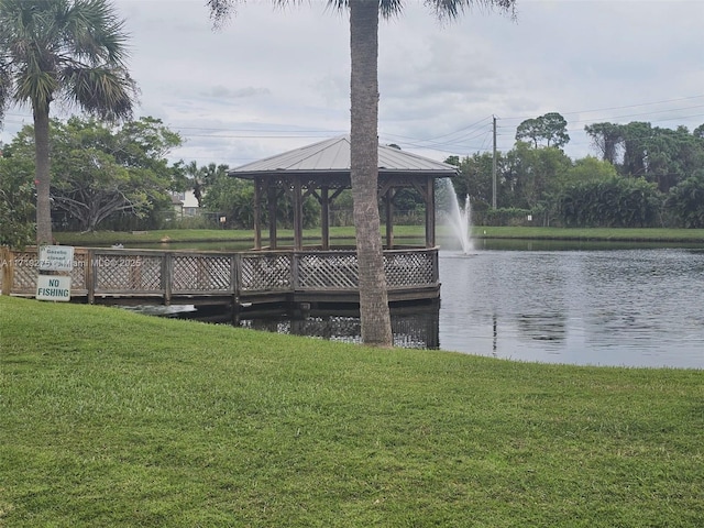 view of dock featuring a gazebo, a water view, and a lawn