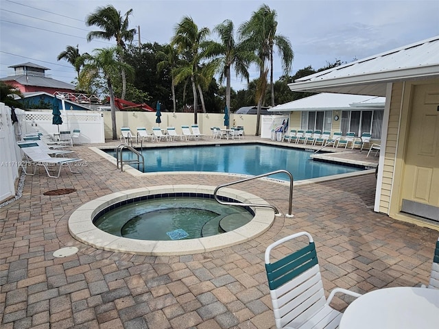 view of swimming pool featuring a community hot tub and a patio area