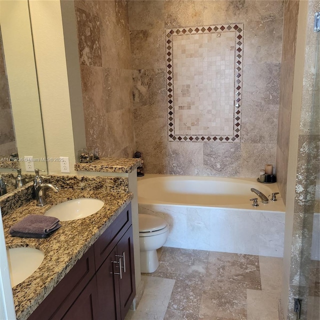 bathroom with vanity, a tub to relax in, and toilet