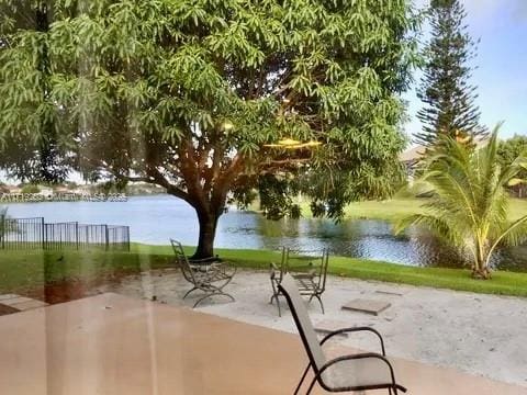 view of property's community with a water view and a patio