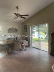 dining area featuring ceiling fan, tile patterned flooring, breakfast area, and vaulted ceiling