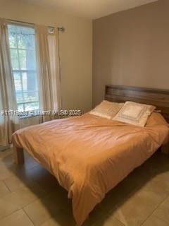 bedroom with multiple windows and tile patterned flooring