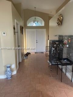 hall featuring tile patterned flooring and a chandelier