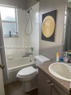 full bathroom featuring tile patterned flooring, vanity, toilet, and tiled shower / bath