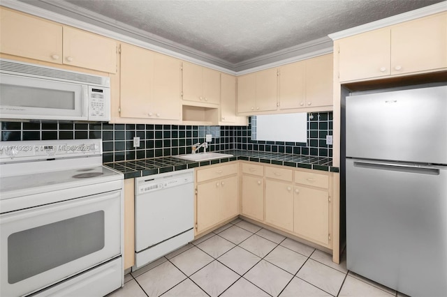 kitchen with tasteful backsplash, sink, white appliances, and tile countertops