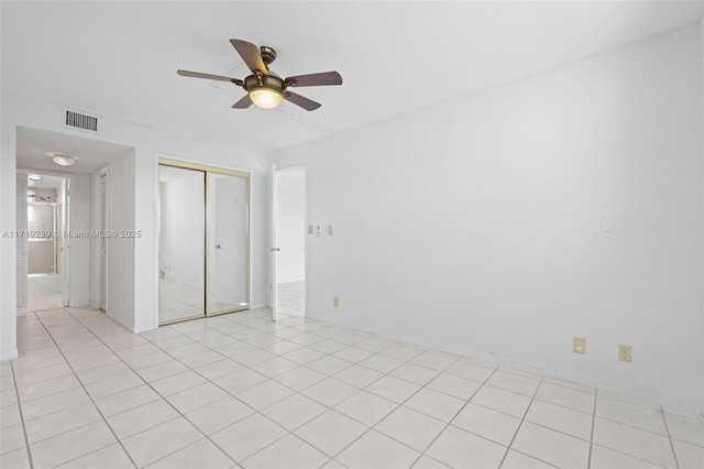 unfurnished bedroom featuring light tile patterned flooring, ceiling fan, and a closet